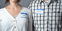 man and woman wearing name tags that read husband and wife
