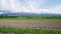 Spring plowed field rural agriculture natural farming in alps landscape

