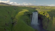 Flight over Skogafoss waterfall in green Iceland.
