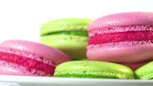 Colorful macaroons rotating, horizontal view. Cooking, food and baking, pastry shop concept. French macarons - meringue cookies with ganache or buttercream filling.