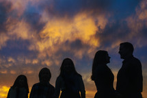 silhouette of a family standing outdoors at sunset 