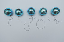 A line of vintage Christmas balls with strings spelling "joy"