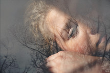 double exposure of a bare tree and woman's face - sorrow 