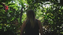 a woman walking through a jungle 