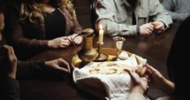 a group praying around a table set for communion 