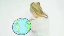 Caucasian girl colouring a map of the earth