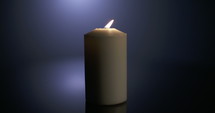 Slow motion macro footage of a white candle on a dark background