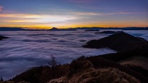  Time lapse of sunrise sky in wild misty nature with wave of low clouds in alpine mountains.
