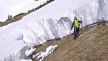Men skier is hiking in big avalanche gap during sunny winter season in alpine mountains.
