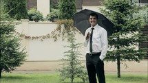 a man standing under an umbrella in the rain 