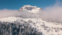 Beautiful rocky peak with misty clouds in sunny winter alps mountains nature Aerial view Outdoor background
