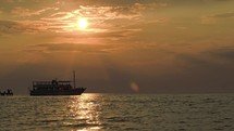 Tourist ship leaving pier at sunset