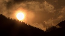 Orange sunset over dark forest silhouette Time lapse
