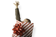 Christmas consumerism - man wrapped in Christmas paper reaching out for help