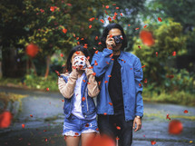 a couple holding camera and falling rose petals 
