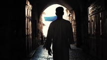 man walking the narrow streets of Via Dolorosa, Israel