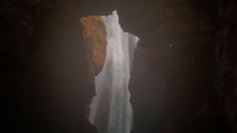 view of a waterfall through a cave 