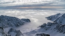 Foggy clouds in winter mountains. Time lapse Zoom out
