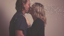 a couple kissing under falling confetti 