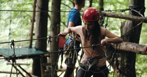 Young woman in helmet on ropes course