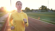 Sportswoman. Female athlete jogging, training before marathon competition on sports track of stadium. Sport running fitness healthy lifestyle active stadium workout exercise.
