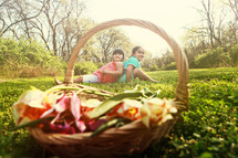 Girls sitting in a field with a flower basket