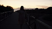 a woman walking across a bridge 