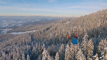 Peaceful flight above winter forest mountains, paragliding adrenaline adventure
