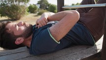 Young Boy Trains Gym Outside In The Park Making Sit Ups