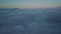 Epic flight down into the clouds at morning sunrise. Aerial slow motion drone shot
