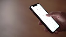 a man scrolling through his smartphone's calendar app 