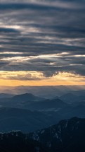 Vertical video of sunrise with golden light of sun over alpine mountains landscape, tourism adventure
