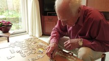 elderly man solving a puzzle 