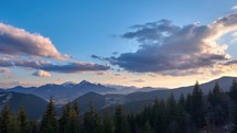 A beautiful panorama of a mountain idyllic landscape with forests and high mountains in the background in the golden hour