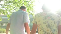 elderly caucasian couple walking holding hands 