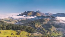 Aerial Hyperlapse of alpine countryside nature with misty clouds motion fast in sunny autumn mountains
