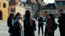 youth with a guide talking outdoors in a town square 