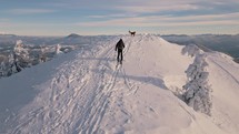 Man Ski touring to the top of the mountain in frozen winter nature Adventure tourism travel
