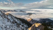 Time lapse of a foggy morning above the clouds flowing in to winter mountains.