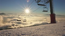 Sunny morning in winter season background in mountains ski resort with empty chairlift in beautiful nature at sunrise
