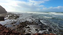 Panoramic view of red rocky ocean coast in sunny summer day in Morocco nature landscape Slow motion
