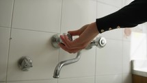 A Woman's Hand Opens The Faucet At Home