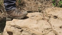 hiking boots walking across rocks