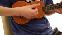 a boy playing a ukulele 