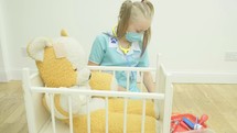 little girl playing doctor with her toys 