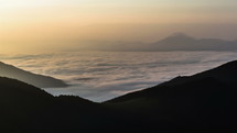 Foggy morning about the clouds in the mountains. Time lapse of sunrise on a sea of waves of mist.