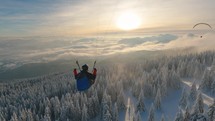 Peaceful evening paragliding flying above frozen forest in winter wonderland nature, Adrenaline outdoor adventure
