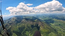 Paragliding flight above green alpine mountains, flying freedom adrenaline adventure
