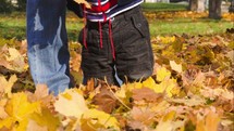 feet of a toddler boy in fall leaves 