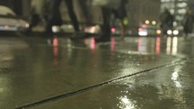 Commuters walking in the rain at night London Bridge, London.